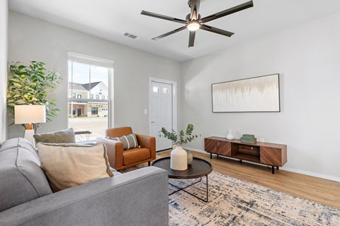 a living room with furniture and a ceiling fan